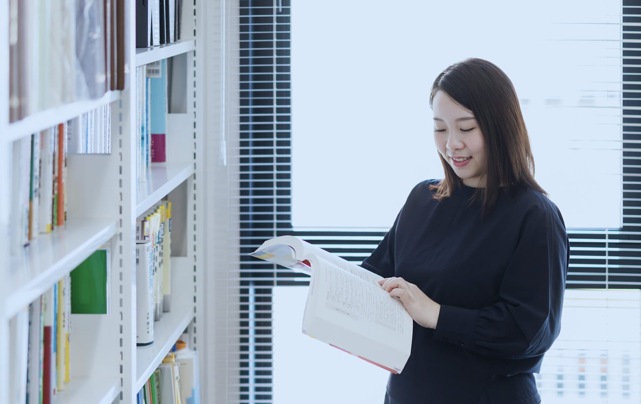 本棚の前で専門書を読む菊地税理士事務所のスタッフ